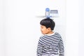 A fat boy is measuring his height himself in hospital Royalty Free Stock Photo
