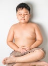 Fat boy meditating in lotus position on chair Royalty Free Stock Photo