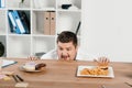 fat businessman choosing donuts or hamburger with french fries Royalty Free Stock Photo