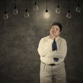 Fat businessman looking at bright lightbulb