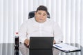 Fat businessman working at his laptop seriously Royalty Free Stock Photo