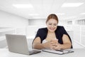 Fat businesswoman with smartphone in office