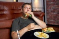 fat caucasian boy with fast food on floor near sofa at home, eating junk food Royalty Free Stock Photo