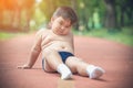 Fat chubby boy tired of exercise, sitting on the running lane park. Fat children need parent attention on weight loss for healthy