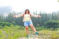 Fat female Asian tourist standing with arms and legs spread.