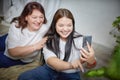 Fat funny funny adult mother and daughter posing, taking selfies indoors. Body positive, friendly family in room Royalty Free Stock Photo