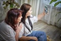 Fat funny funny adult mother and daughter posing, taking selfies indoors. Body positive, friendly family in room Royalty Free Stock Photo