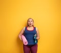 Fat girl does gym at home. surprised expression. Yellow background