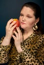 Fat girl holding a red apple near her face. Compliance with the diet. Royalty Free Stock Photo