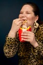 A fat girl is not appetizing, disgusting french fries from a glass. The concept of gluttony.