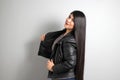 Fat latin young adult woman shows off her beautiful very long straight black shiny silky hair wears black fur jacket looks modern, Royalty Free Stock Photo