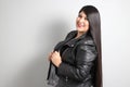 Fat latin young adult woman shows off her beautiful very long straight black shiny silky hair wears black fur jacket looks modern, Royalty Free Stock Photo