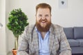 Fat man with a beard looks at the camera online using a webcam video chat conference sitting at home office. Royalty Free Stock Photo