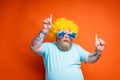 Fat man with beard, tattoos and sunglasses dances music on a disco Royalty Free Stock Photo