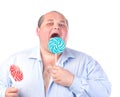 Fat Man in a Blue Shirt, Eating a Lollipop Royalty Free Stock Photo