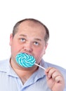 Fat Man in a Blue Shirt, Eating a Lollipop Royalty Free Stock Photo