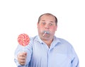 Fat Man in a Blue Shirt, Eating a Lollipop Royalty Free Stock Photo