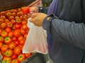 Fat man buying red tomato in the supermarket