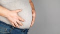 Fat man, checking his weight, on a gray background Royalty Free Stock Photo