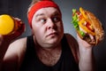 Fat man choise between sport and fastfood Royalty Free Stock Photo