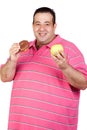 Fat man deciding between a candy and an apple Royalty Free Stock Photo