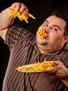 Fat man eating fast food french fries for overweight person.