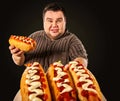 Fat man eating fast food hot dog. Breakfast for overweight person. Royalty Free Stock Photo