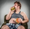 Fat man eating hamburger Royalty Free Stock Photo