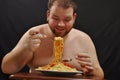 Fat man eating pasta