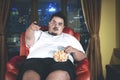 Fat man eats popcorn during watch television Royalty Free Stock Photo