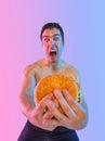 Fat man with fast food. Not sporty men eating hamburger on purple background. Concept for dietetics and fitness