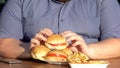 Fat man holding hamburger, unhealthy food, calories and diet, obesity problem Royalty Free Stock Photo