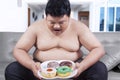 Fat man holding a plate of donuts Royalty Free Stock Photo