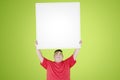 Fat man lifting a blank whiteboard in the studio Royalty Free Stock Photo