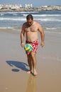 Fat man playing with a ball on the beach Royalty Free Stock Photo