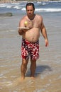 Fat man playing beach tennis on the beach