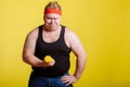 Fat man try to lift small yellow dambbell Royalty Free Stock Photo