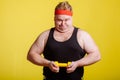 Fat man try to lift small yellow dambbell Royalty Free Stock Photo