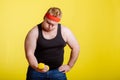 Fat man try to lift small yellow dambbell Royalty Free Stock Photo