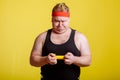 Fat man try to lift small yellow dambbell Royalty Free Stock Photo