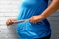 Fat man using measuring tape to measuring his belly Royalty Free Stock Photo