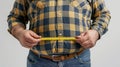 a fat man is using Waist measuring tape to measure his waist, overweight concept Royalty Free Stock Photo