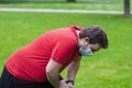 Fat man wearing face mask doing exercises after quarantine