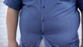 Fat man wearing tight blue shirt, appearance insecurities, hormonal disbalance