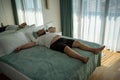Fat oversize man suffer dying from heat. Lazy, obese overweight guy lies on bed, feels tired in room