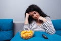 Fat overweight woman with chips while watching TV. Sedentary lif