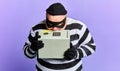 Fat plump prisoner in striped clothes opening the safe with teeth Royalty Free Stock Photo