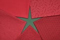 Fat quarters of fabrics red colors lying in the shape like a star on green fabric