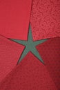 Fat quarters of fabrics red colors lying in the shape like a star on green fabric