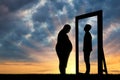 Fat sad man and his reflection in the mirror of a normal man against sky. Royalty Free Stock Photo